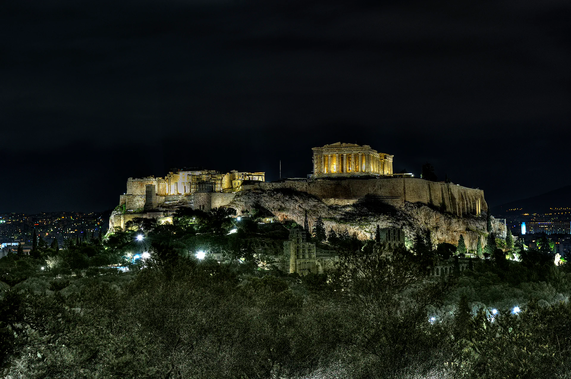 Lit-up ruins of the Acropolis hill at night in Athens.