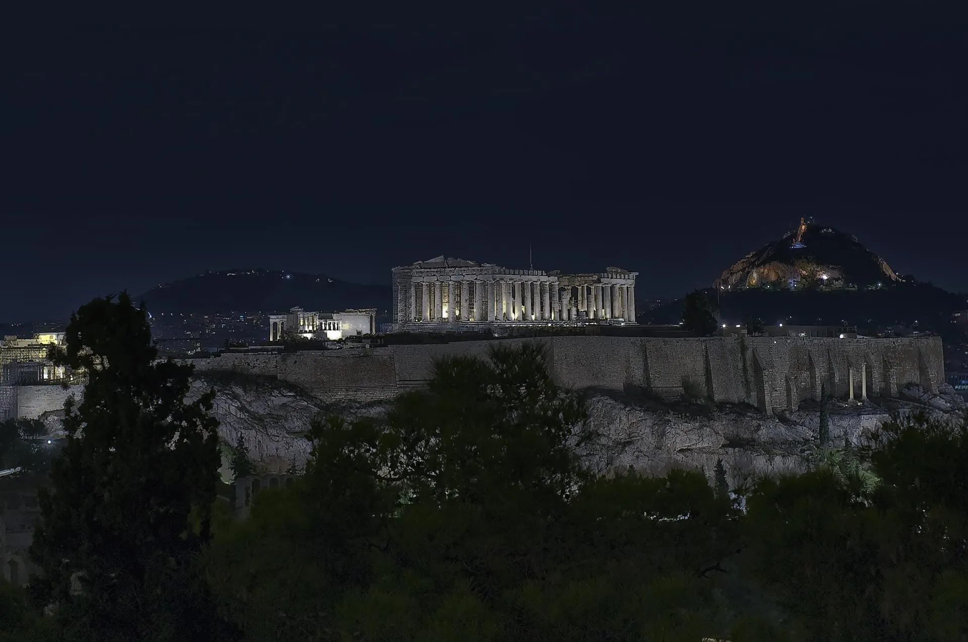 Golden spotlight on the Acropolis ruins after dark