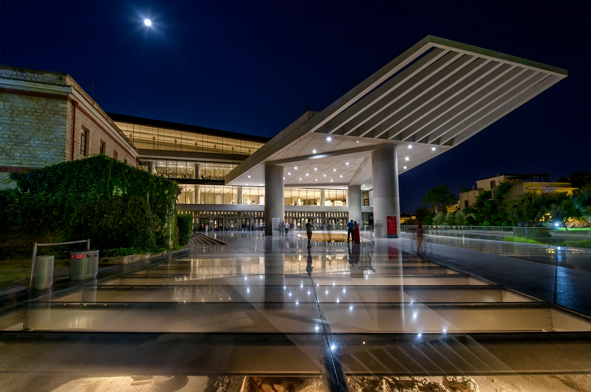 Night view of the illuminated Acropolis Museum with modern architecture.