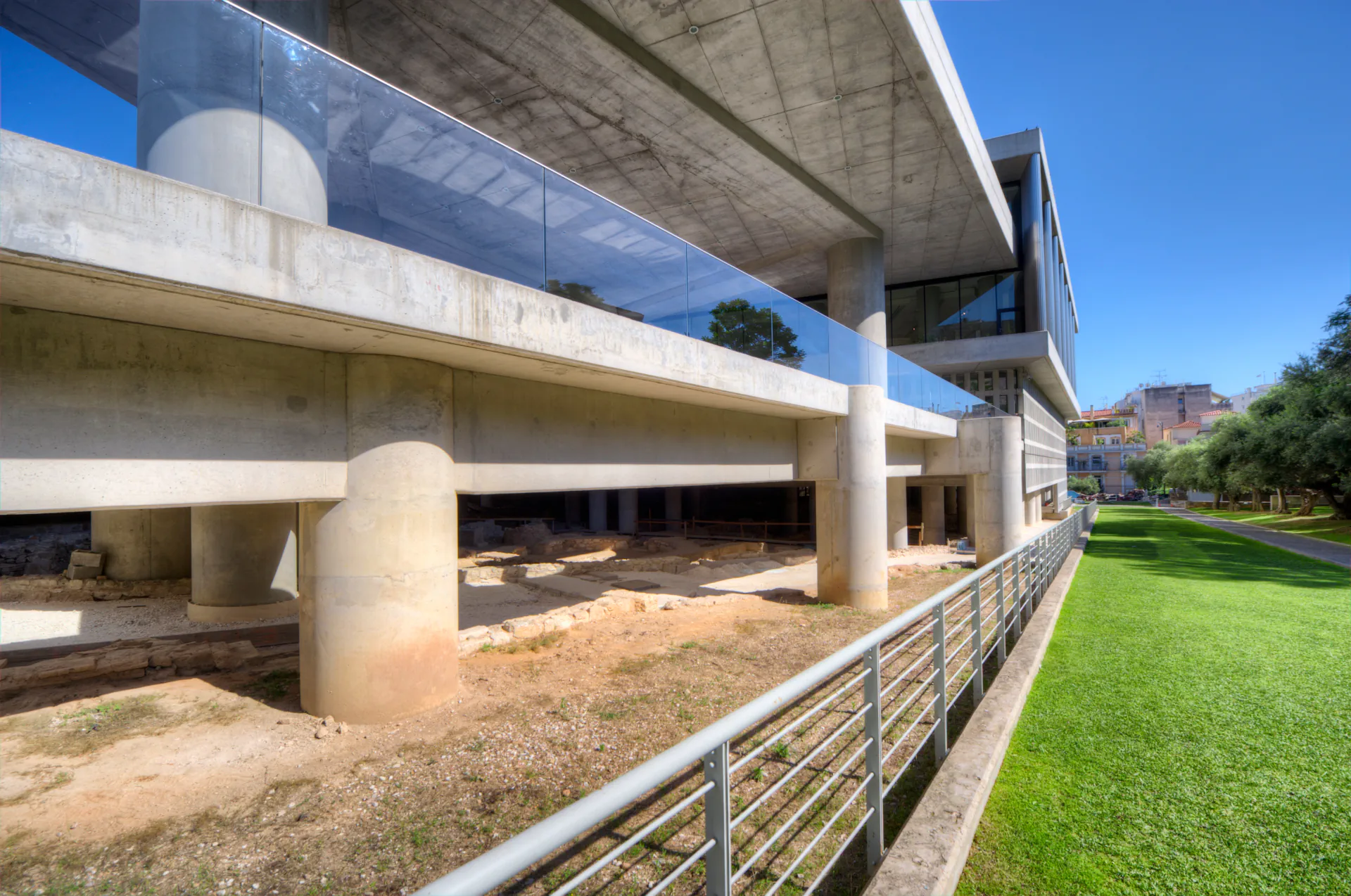 Modern exterior of the Acropolis Museum with glass and concrete architecture.