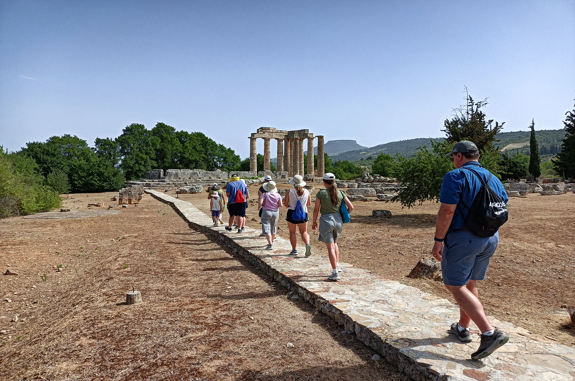 Tourists walking through the ancient athletic grounds of Nemea.