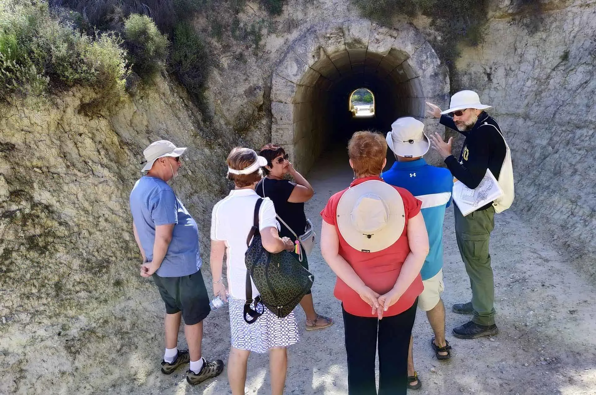 Tourists walking through the ancient athletic grounds of Nemea.