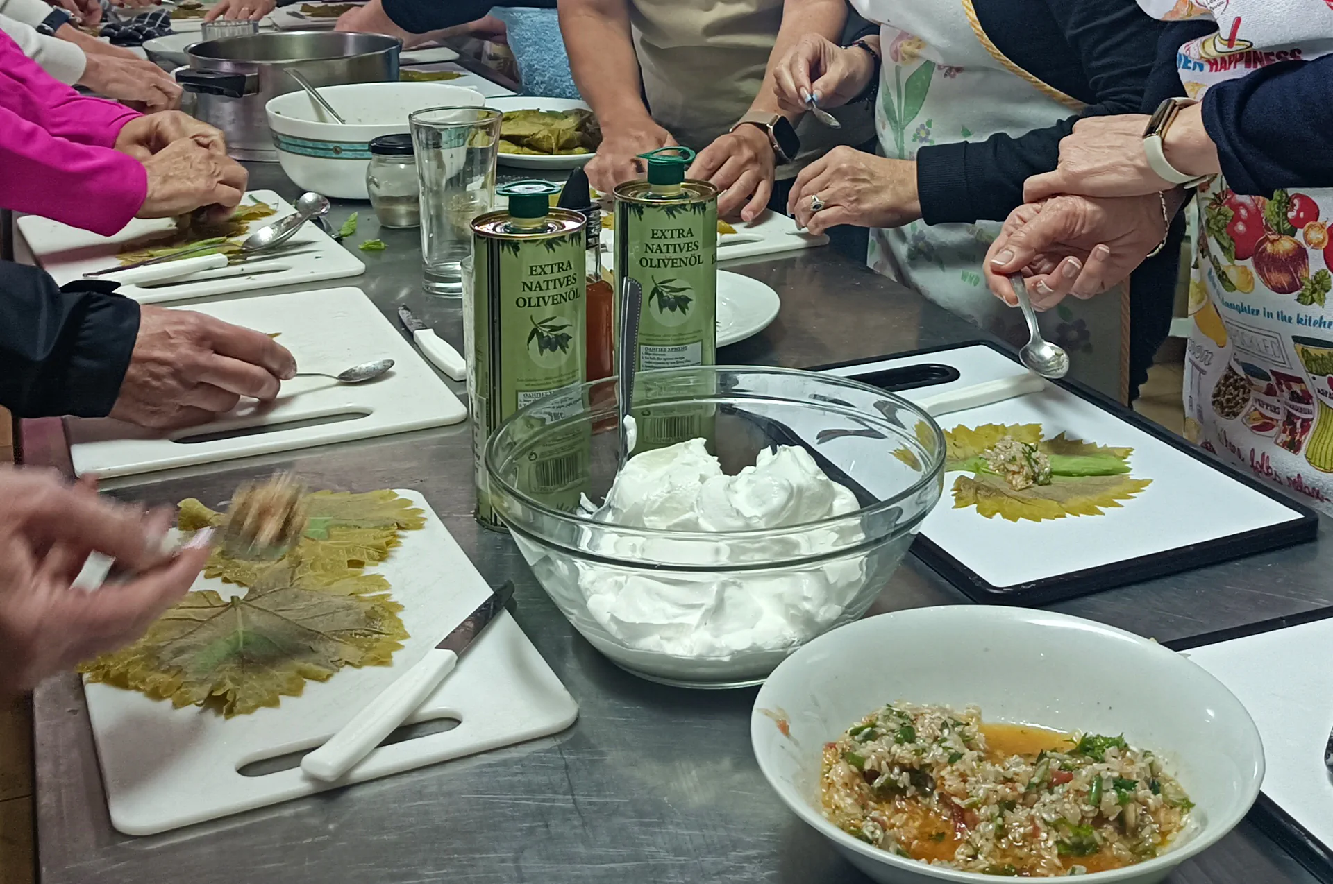 Guests carefully roll vine leaves filled with rice, herbs, and love.
