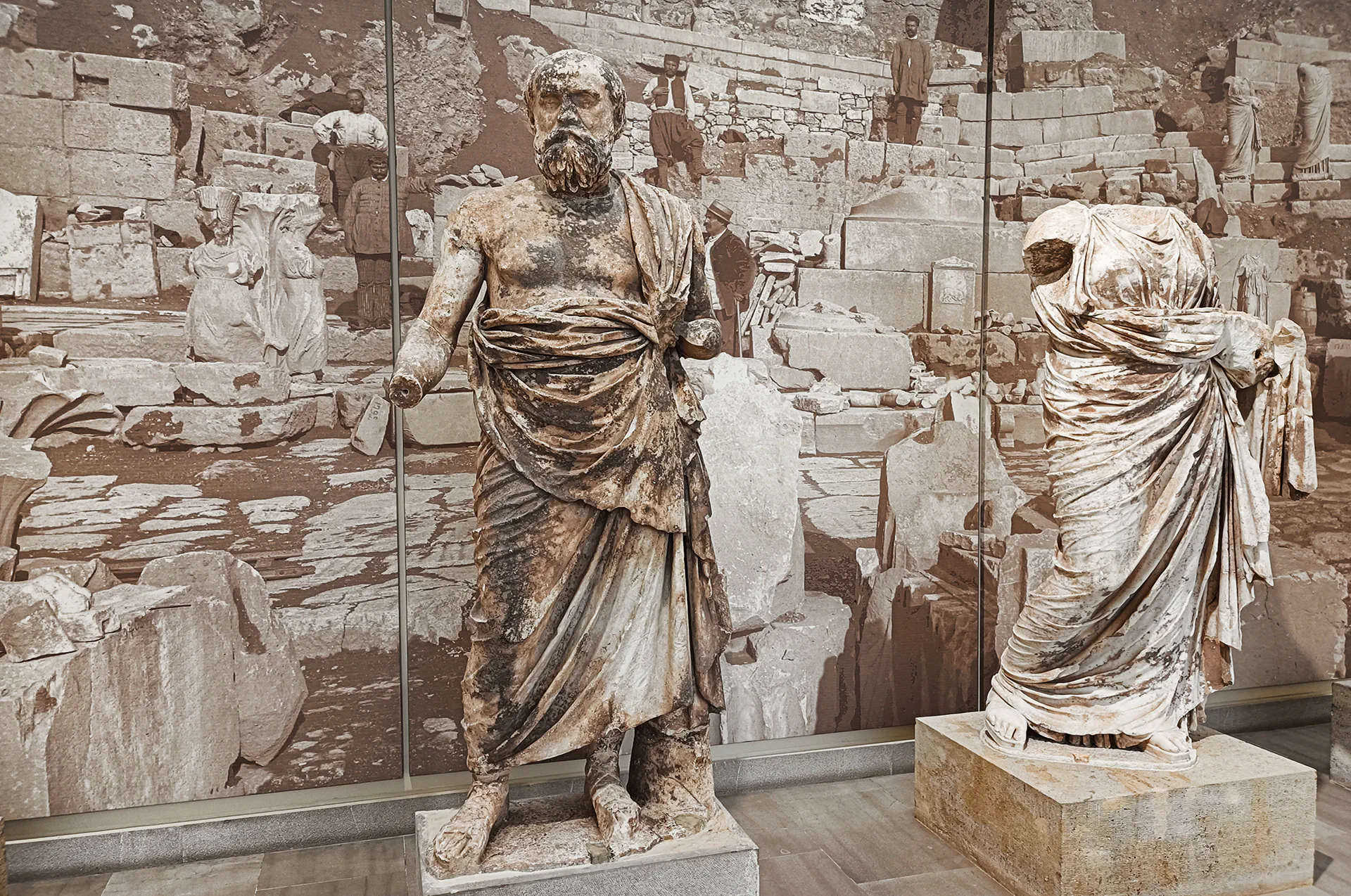 Marble statues from classical Greece in museum exhibit.