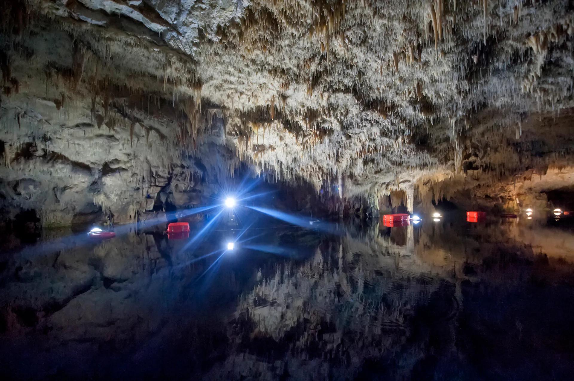 Stalagmites and stalactites meeting above water.