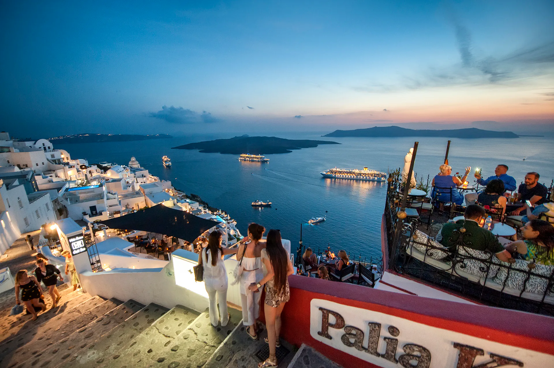 Evening lights twinkling across Fira’s hillside homes.