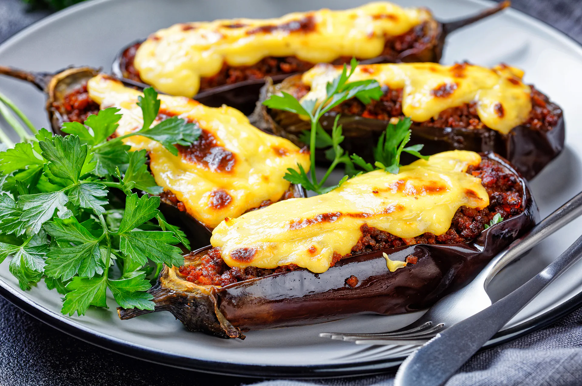 Baked Greek Eggplant Papoutsaki stuffed with minced meat and topped with cheese