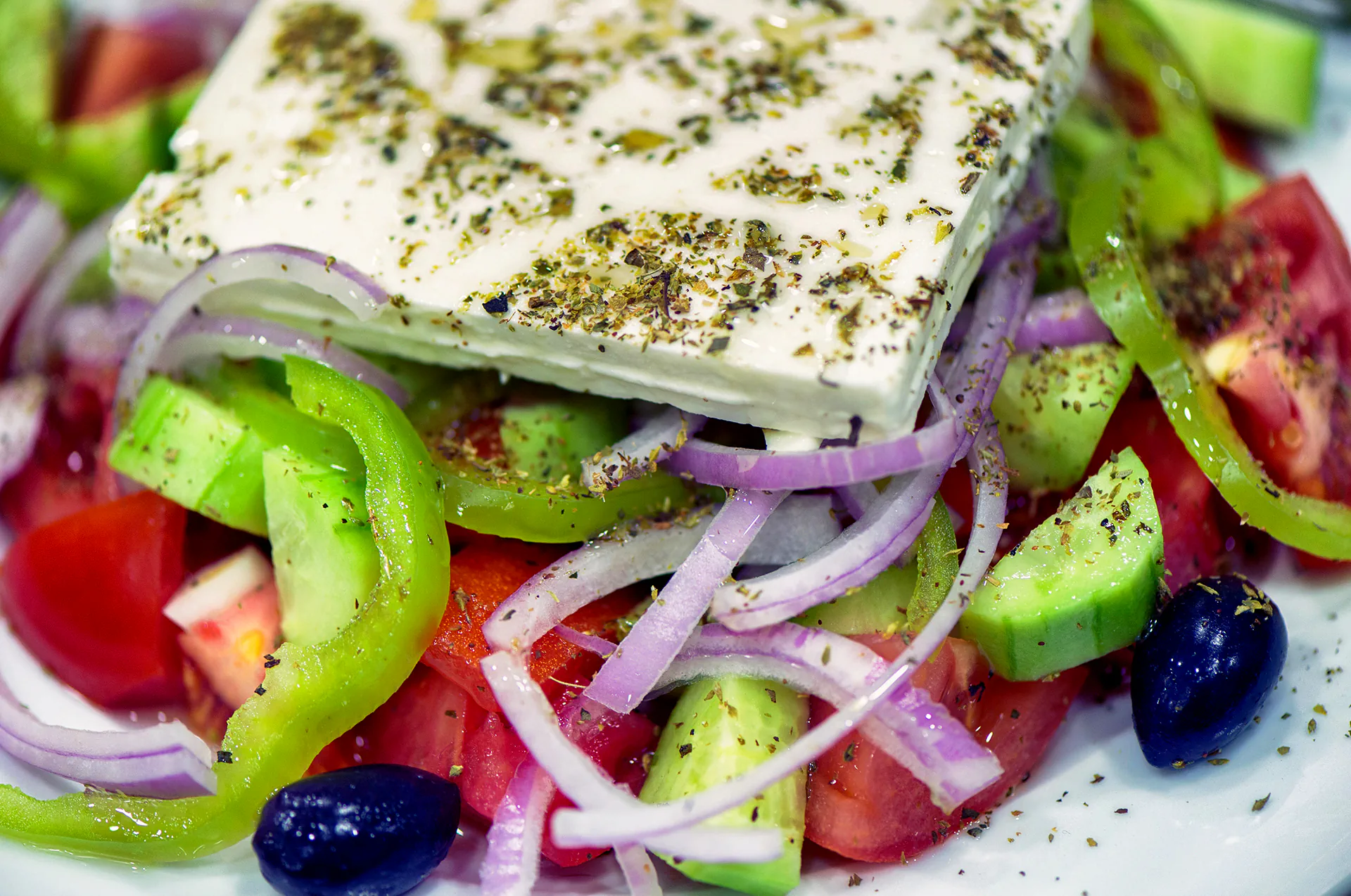 Close-up of colorful Greek salad drizzled with olive oil