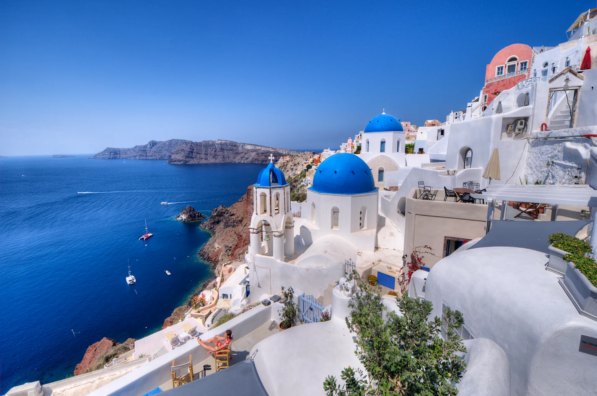View of the Aegean Sea and volcano from Imerovigli rooftops.