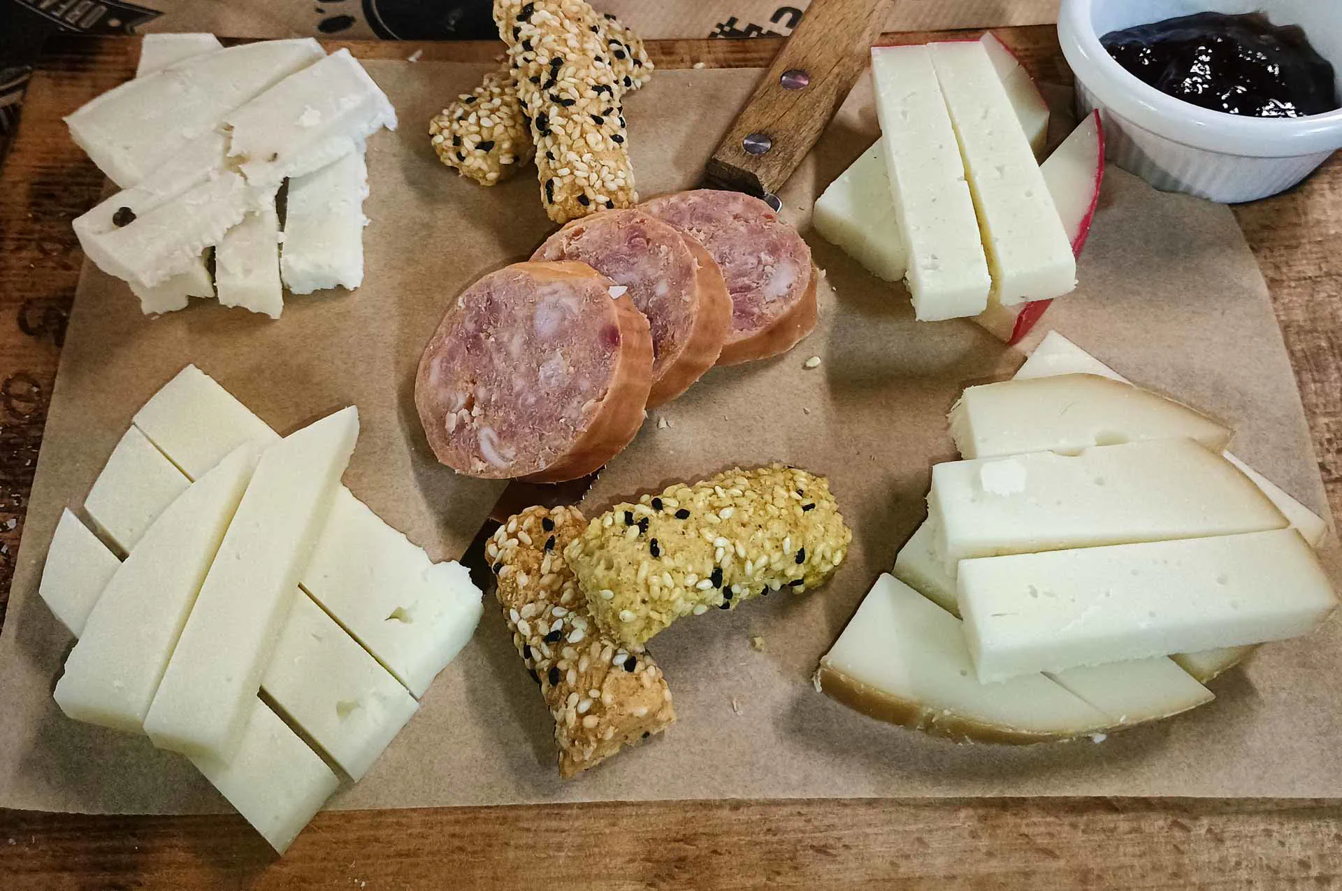 Slices of Metsovone cheese, a smoked semi-hard cheese from Metsovo, Greece, served on a wooden board.