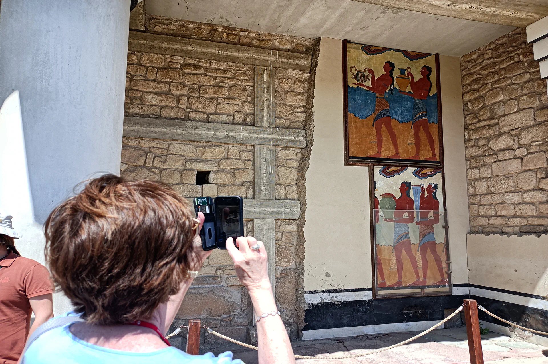 Reconstructed frescoes including dolphins and bull motifs on palace walls.