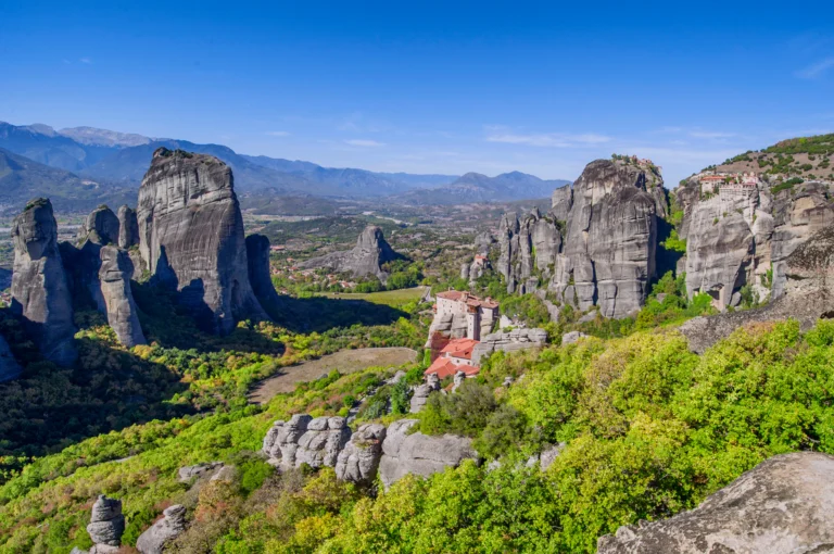 Meteora Travel Guide | Hiking, Monasteries & Scenic Views Monasteries of Meteora perched atop massive rock formations, offering a breathtaking view of the mystical mainland and its awe-inspiring landscape.