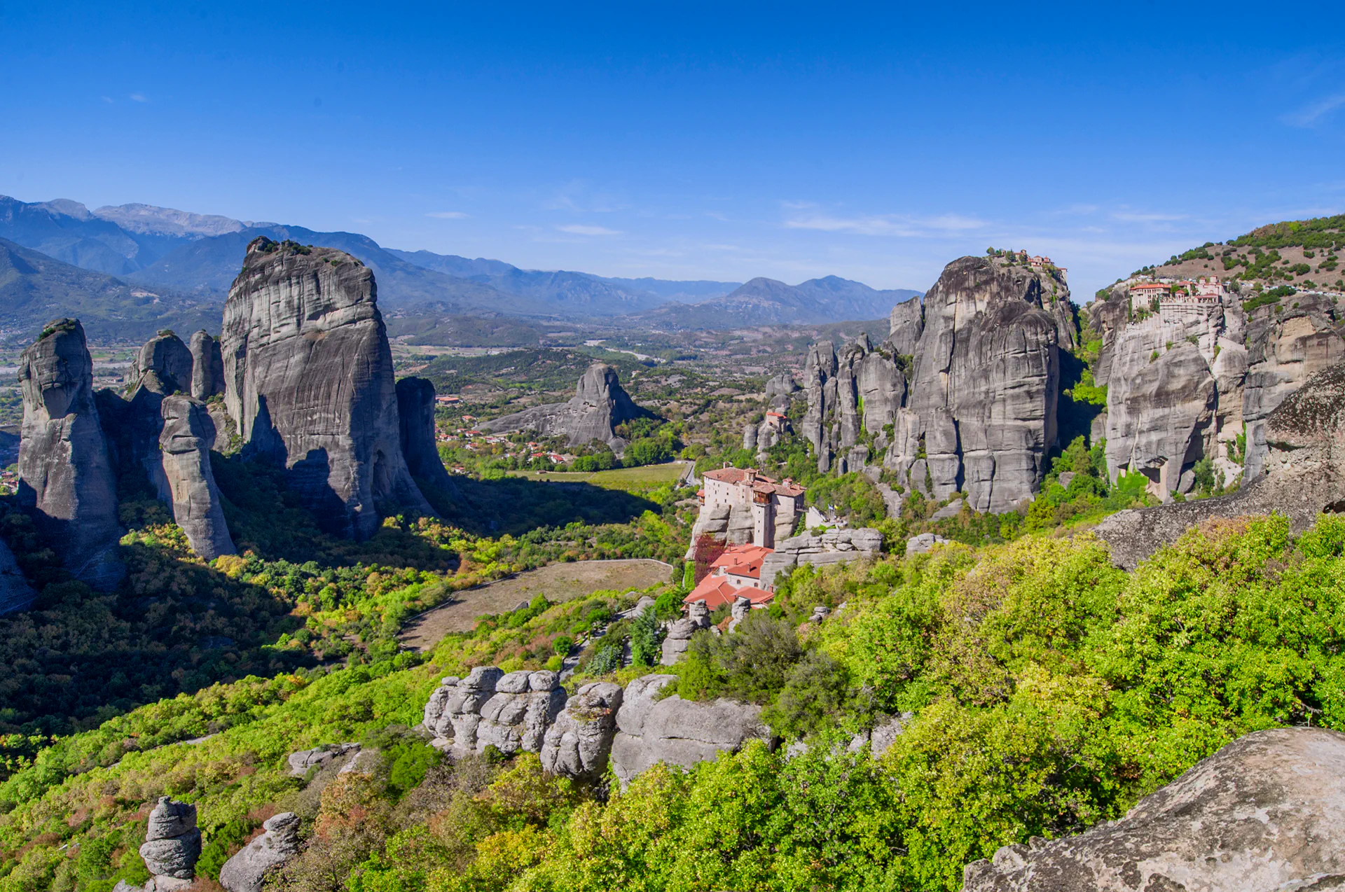Monasteries of Meteora perched atop massive rock formations, offering a breathtaking view of the mystical mainland and its awe-inspiring landscape.