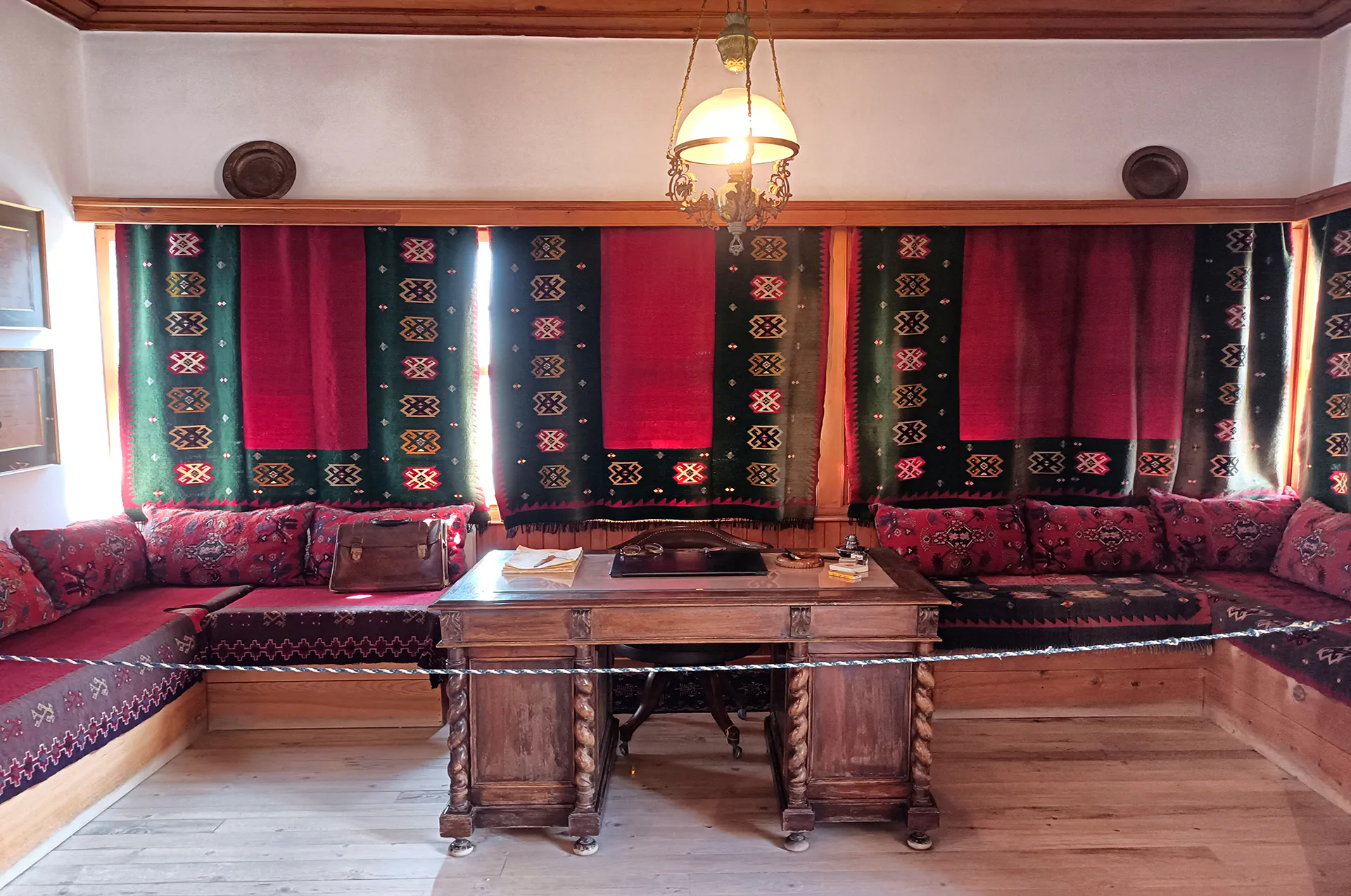 Traditional wooden office table with inkwell, books, and vintage writing tools in the study room of the Metsovo Folk Art Museum.