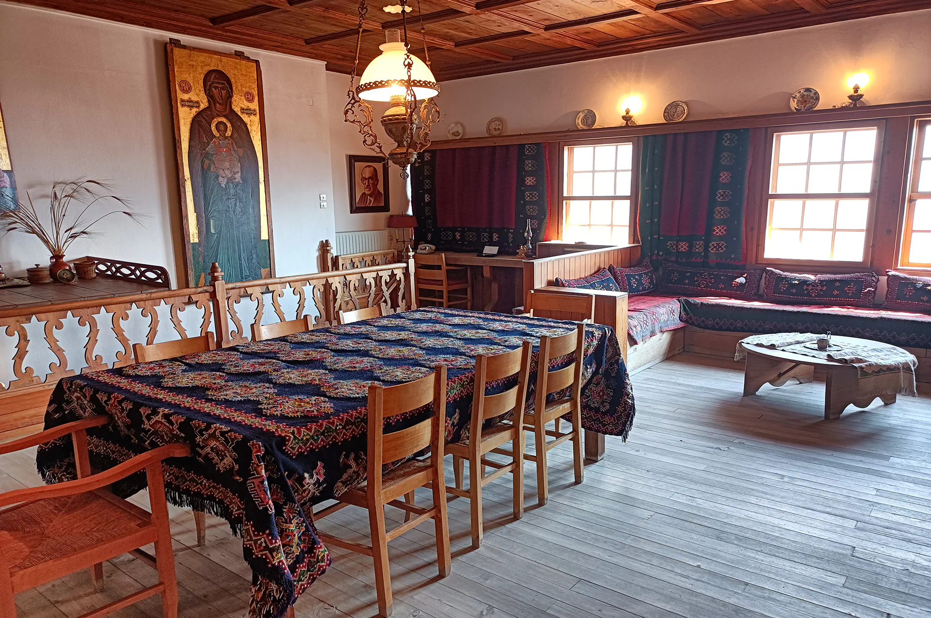 Period dining room with antique wooden chairs, a carved table, and embroidered linen tablecloth on display.