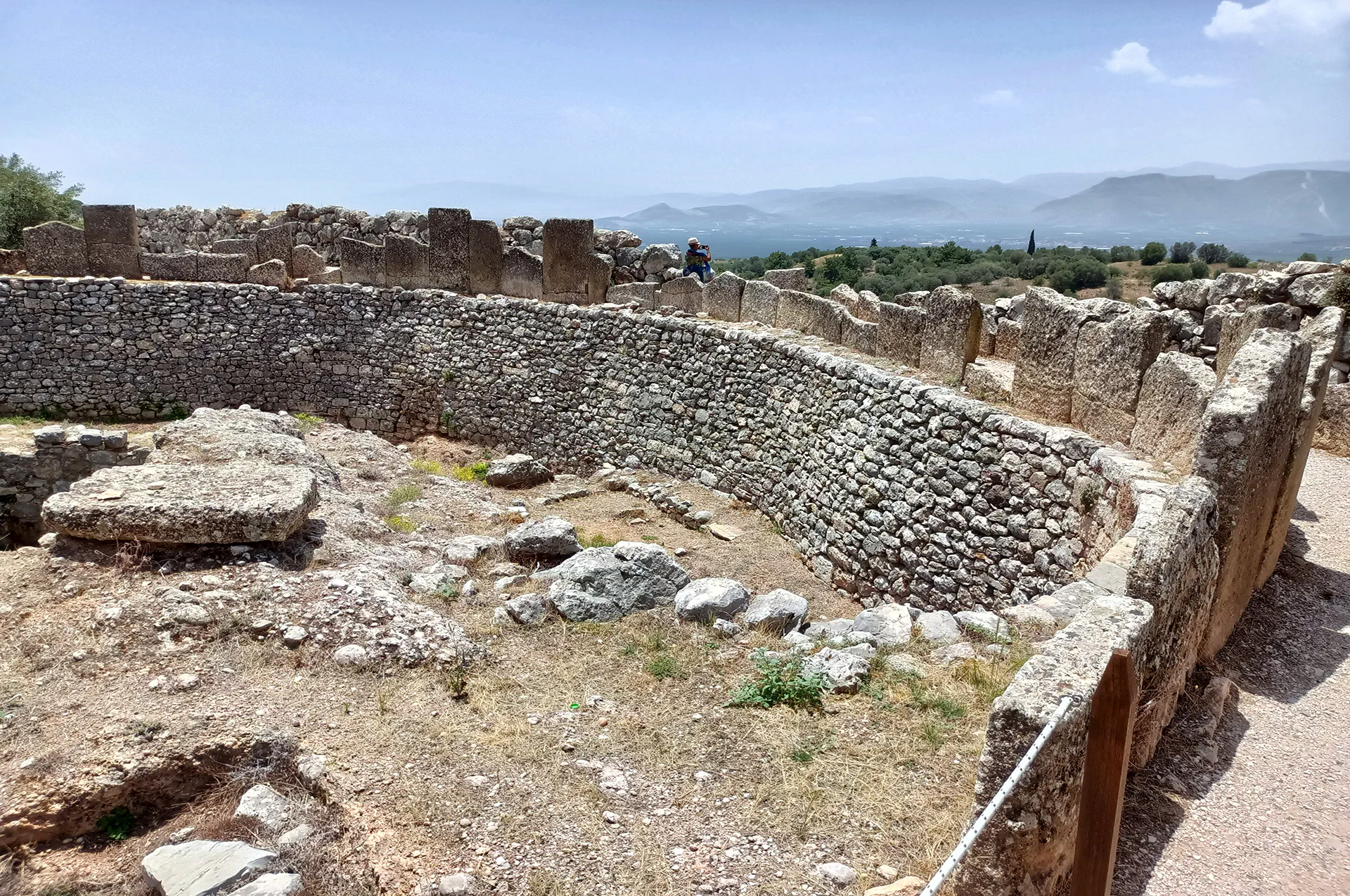 Tourists exploring the ancient ruins of Mycenae, an iconic archaeological site in Greece