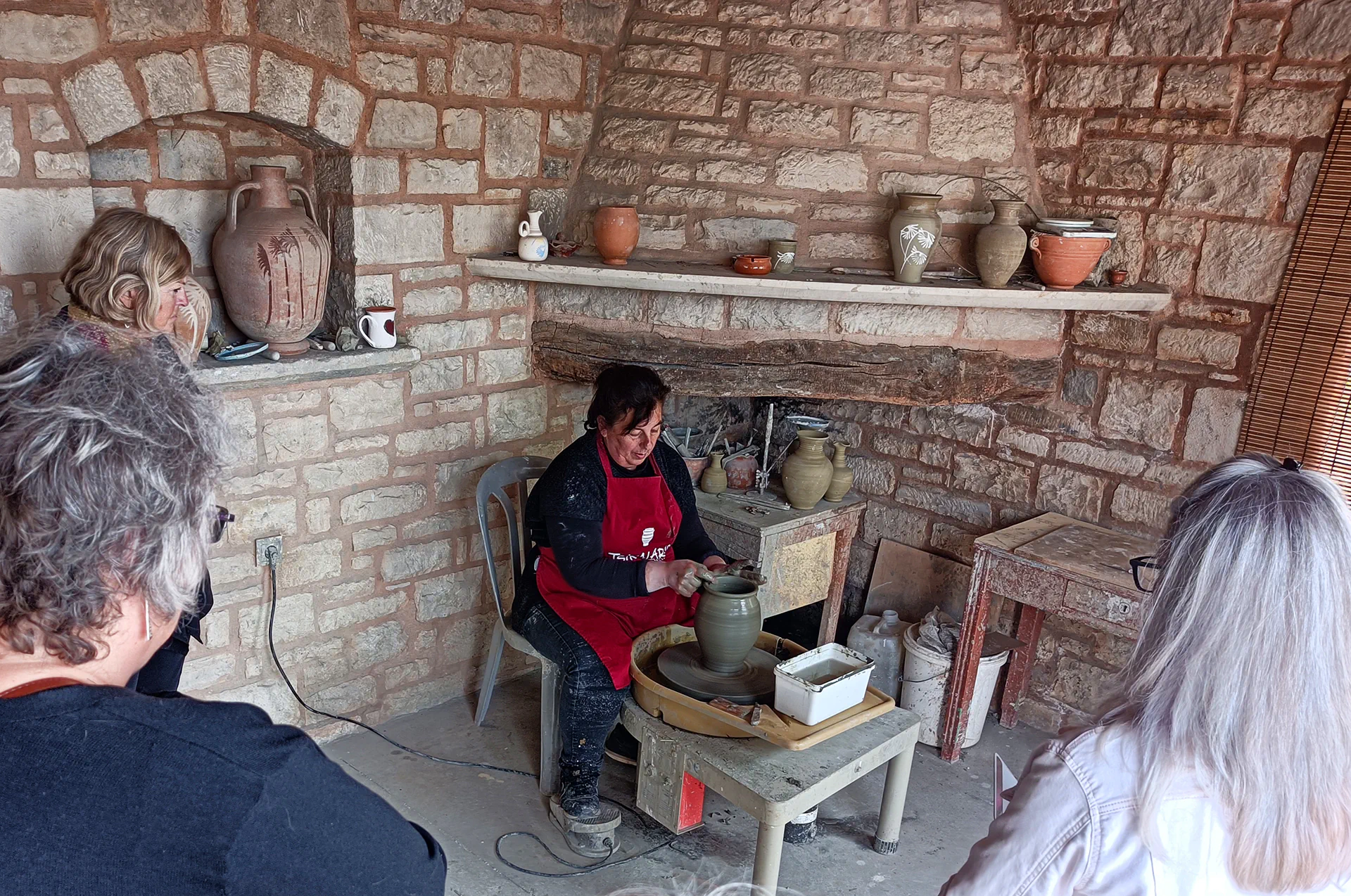 Cretan potter shaping clay on a wheel at Tsikalario workshop.